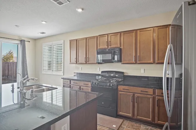 a kitchen with stainless steel appliances granite countertop a sink stove and cabinets