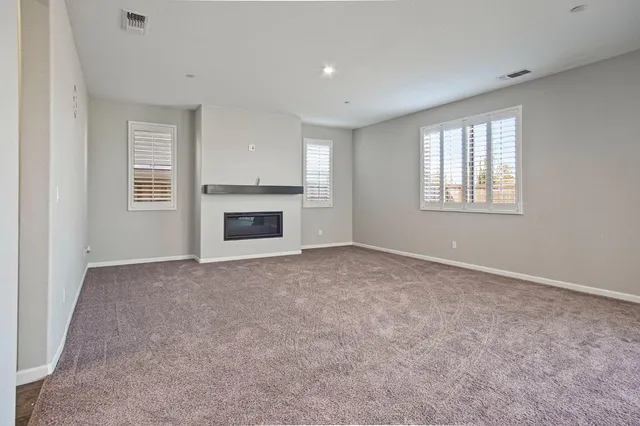 a view of empty room with a fireplace and windows