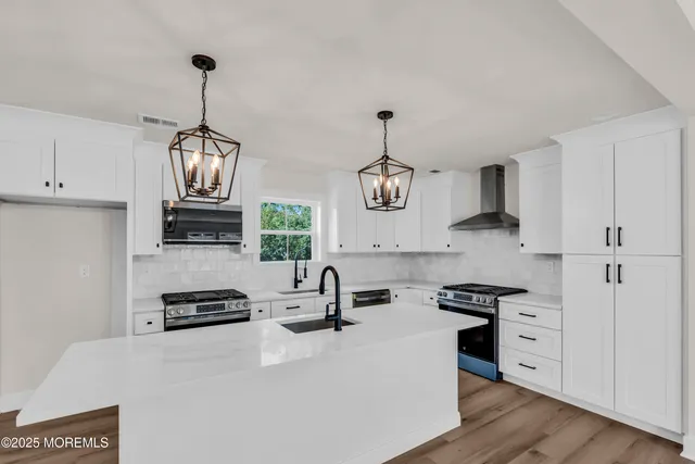 a kitchen with stainless steel appliances a stove a sink and a refrigerator