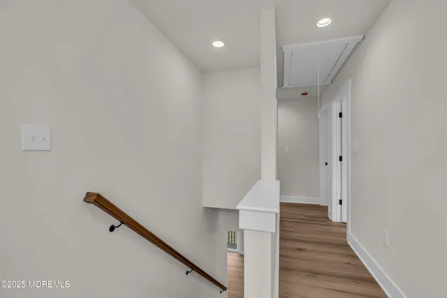 a view of a hallway with wooden floor and a window
