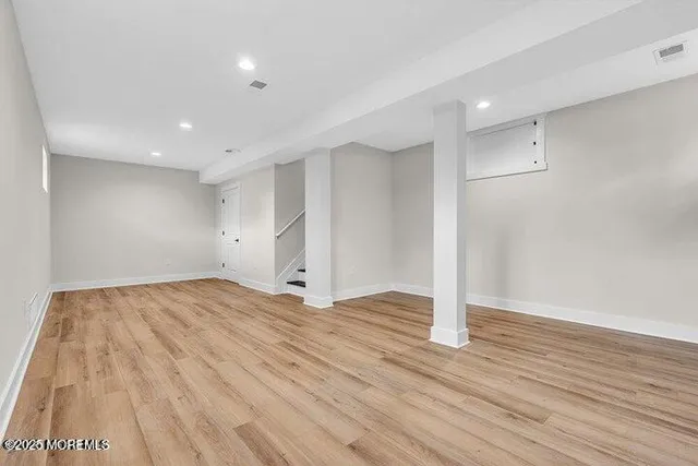 an empty room with wooden floor and white walls