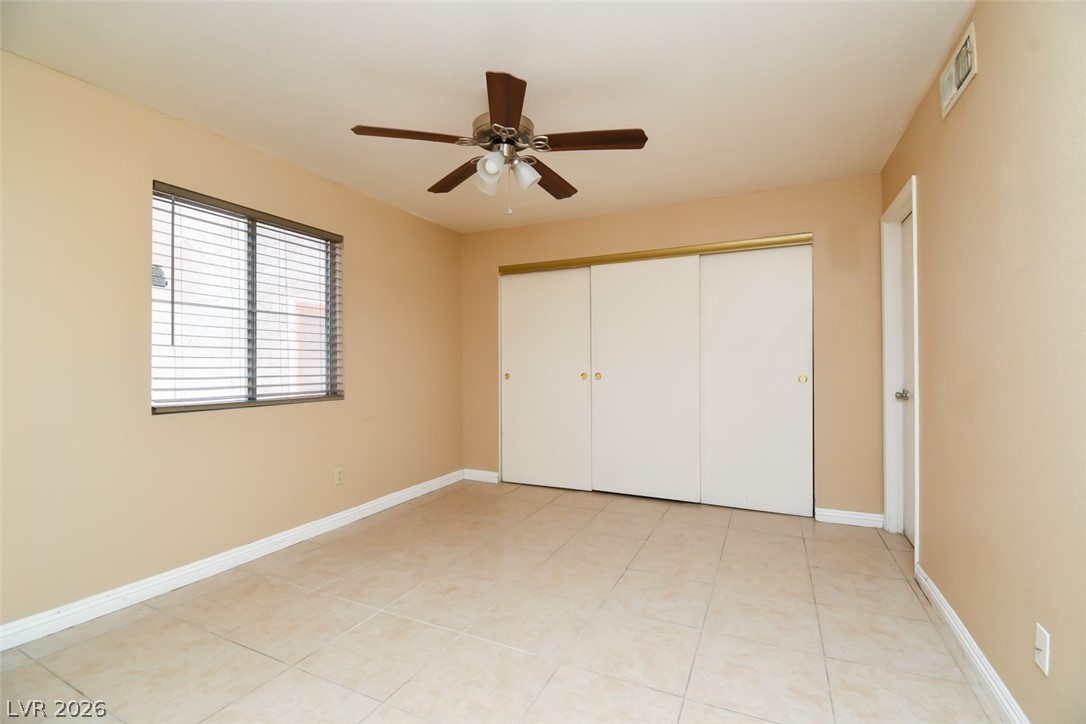 7570 West Flamingo Road, Unit 119 Las Vegas, NV 89147 - Photo 8 of 15 A well-lit bedroom features durable tile flooring and convenient sliding closet doors.