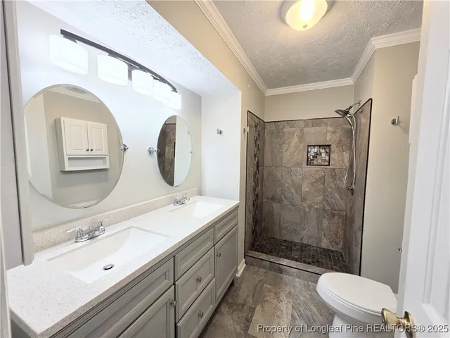 a spacious bathroom with a double vanity sink toilet mirror and shower