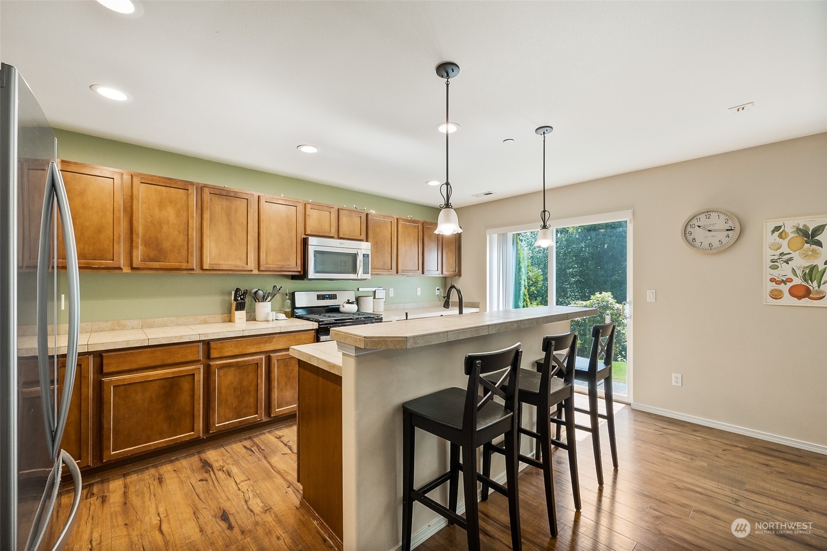 1345 Foreman Road DuPont, WA 98327 - Photo 7 of 34 a kitchen with a table chairs refrigerator and microwave