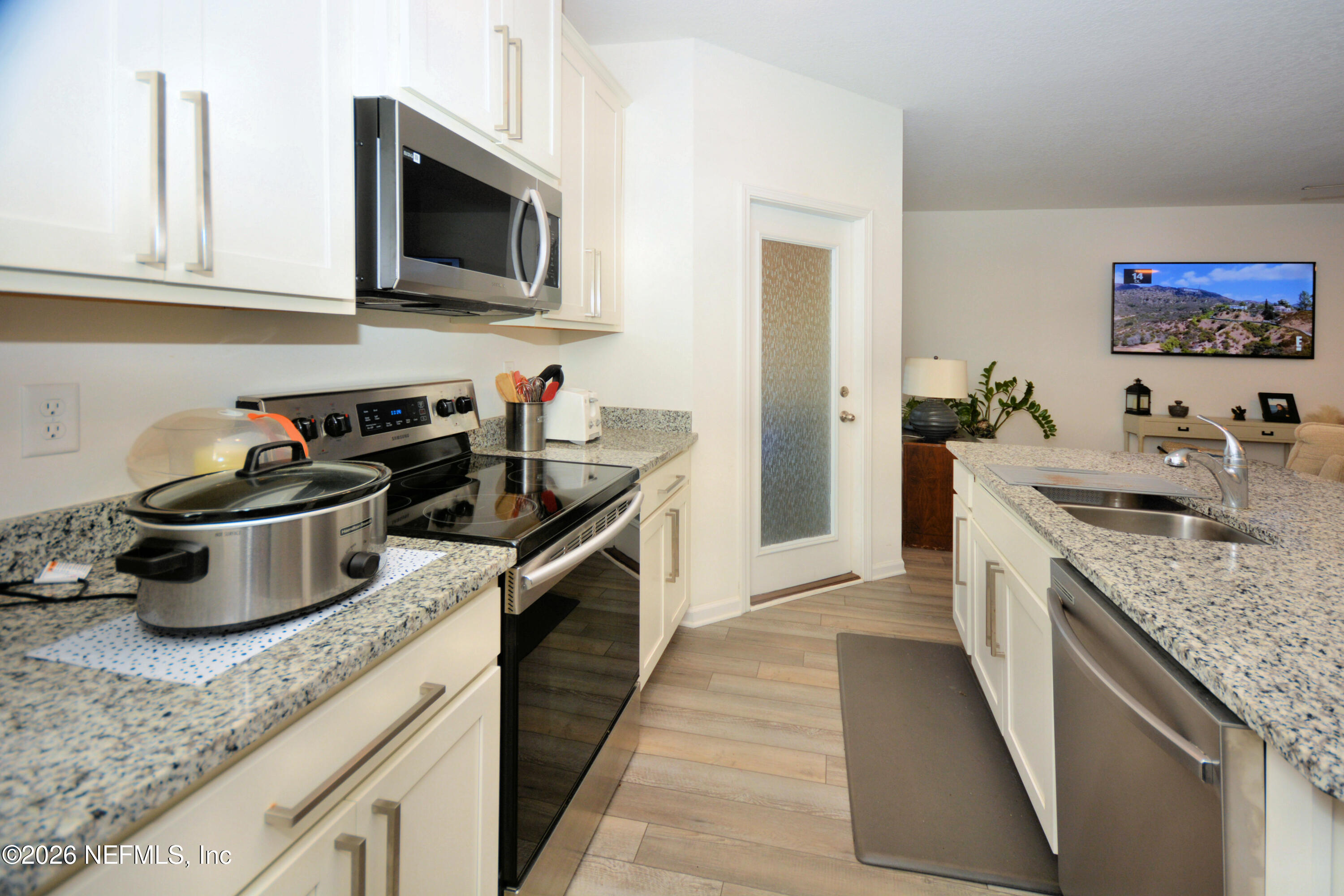 1688 Sanctuary Way Fleming Island, FL 32003 - Photo 11 of 35 a kitchen with a sink stove top oven and microwave