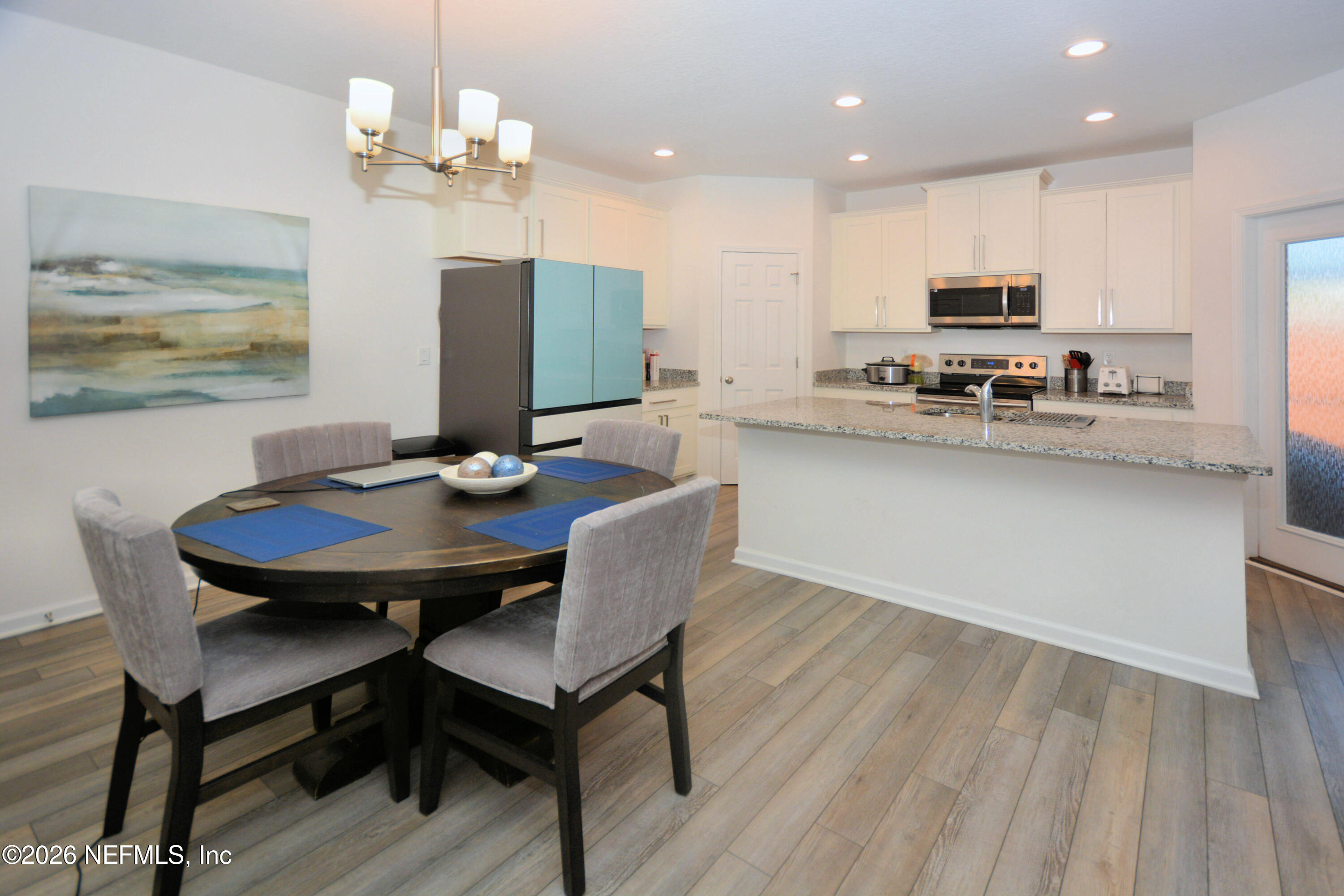 1688 Sanctuary Way Fleming Island, FL 32003 - Photo 15 of 35 a view of a dining room with furniture wooden floor and chandelier