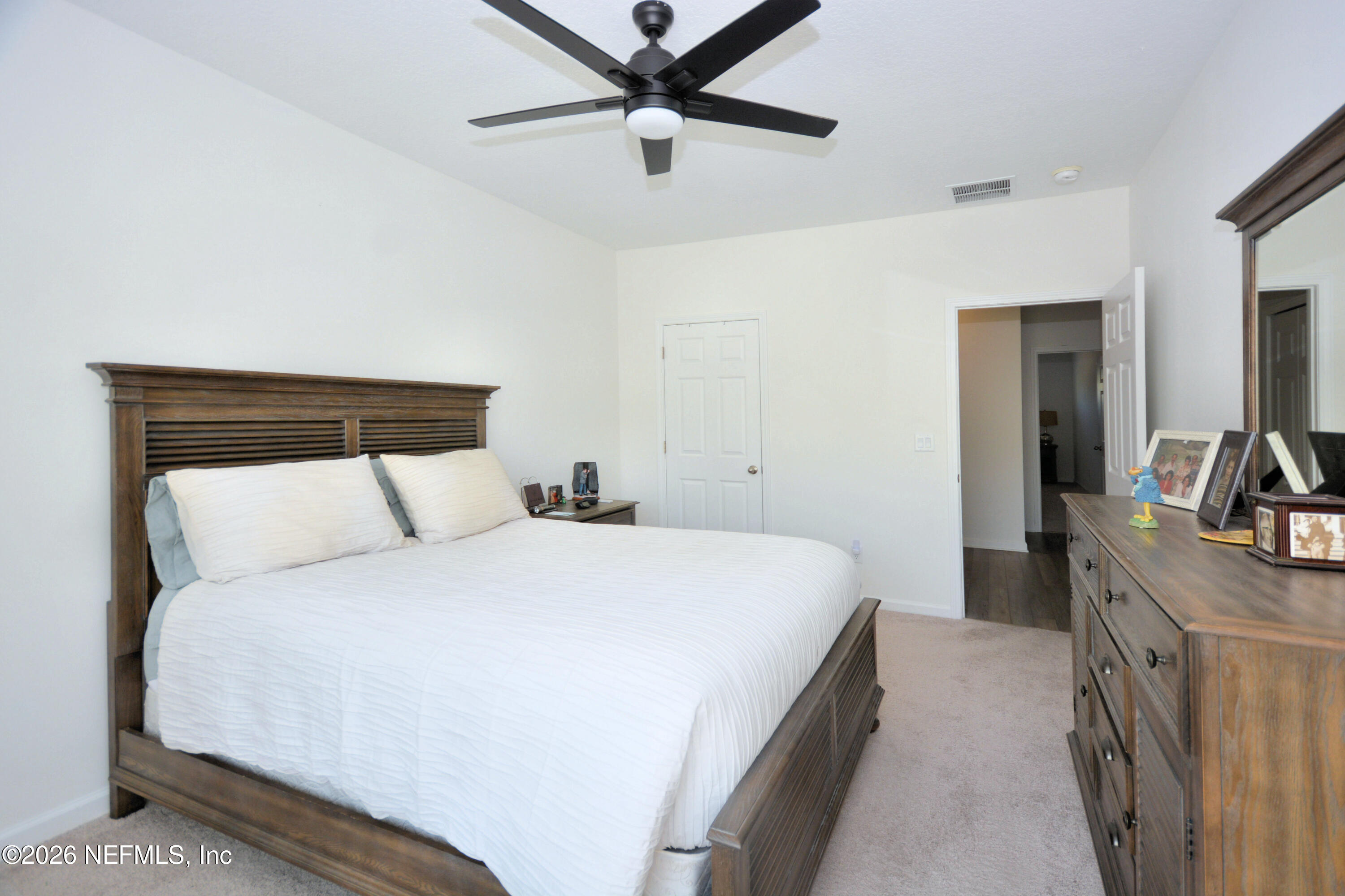 1688 Sanctuary Way Fleming Island, FL 32003 - Photo 21 of 35 a bedroom with a bed and a chandelier