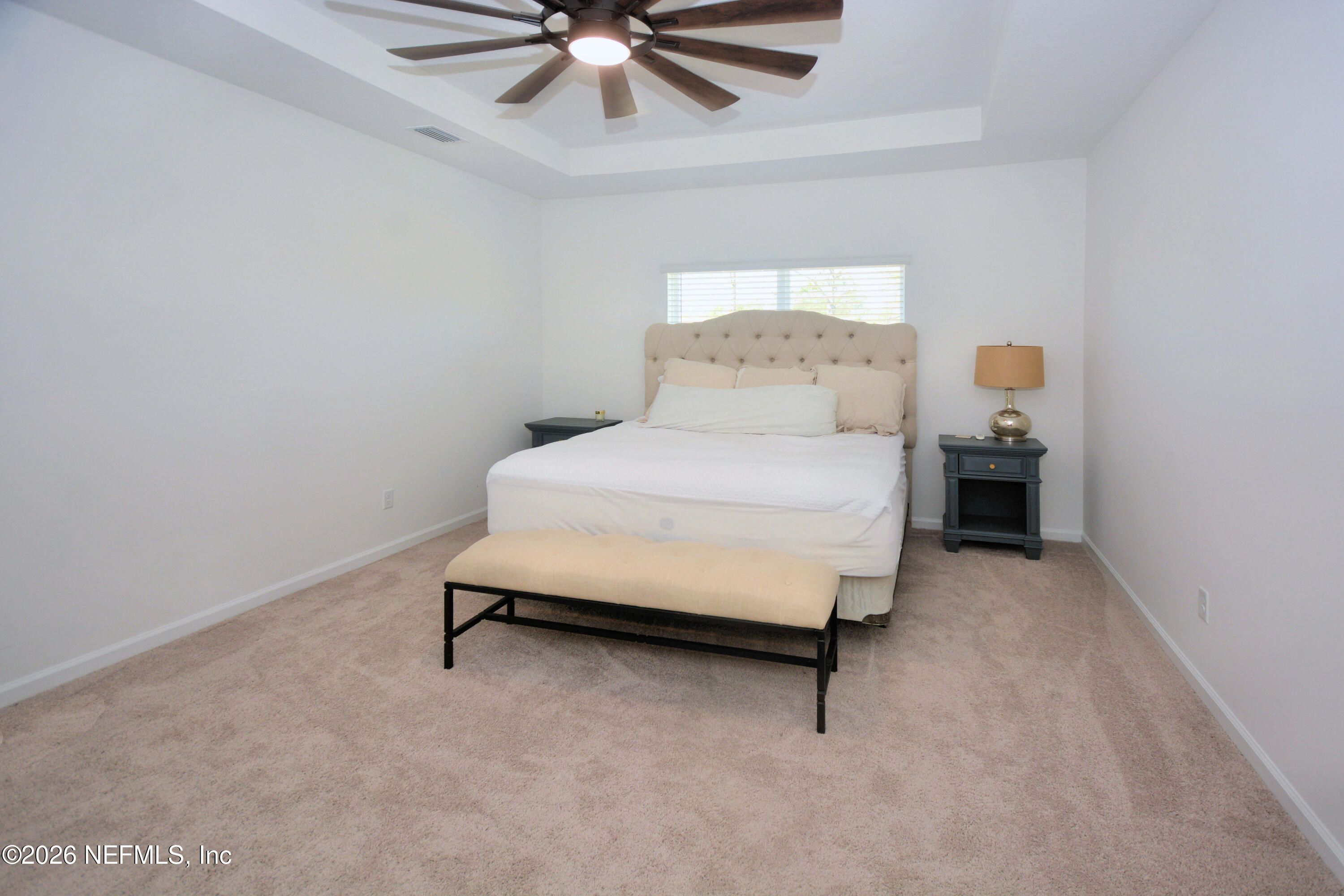 1688 Sanctuary Way Fleming Island, FL 32003 - Photo 28 of 35 a bedroom with a bed and a chandelier