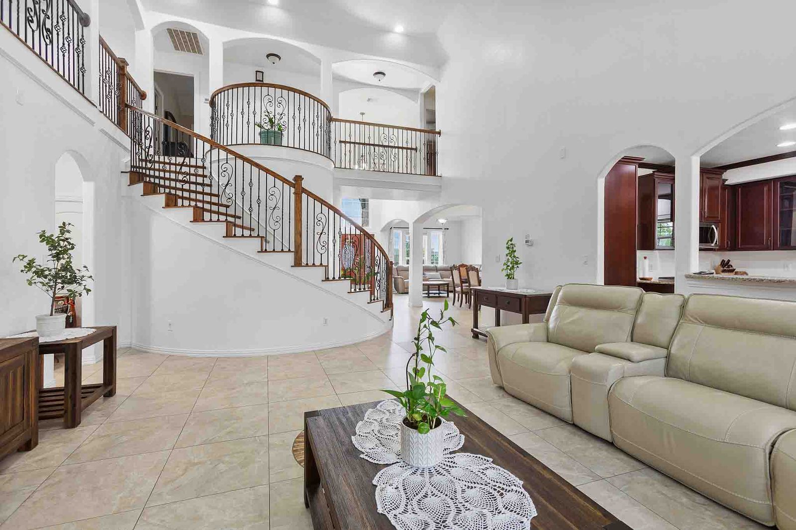 Two-story foyer featuring a curved staircase with wrought iron balusters and wood-finish handrails