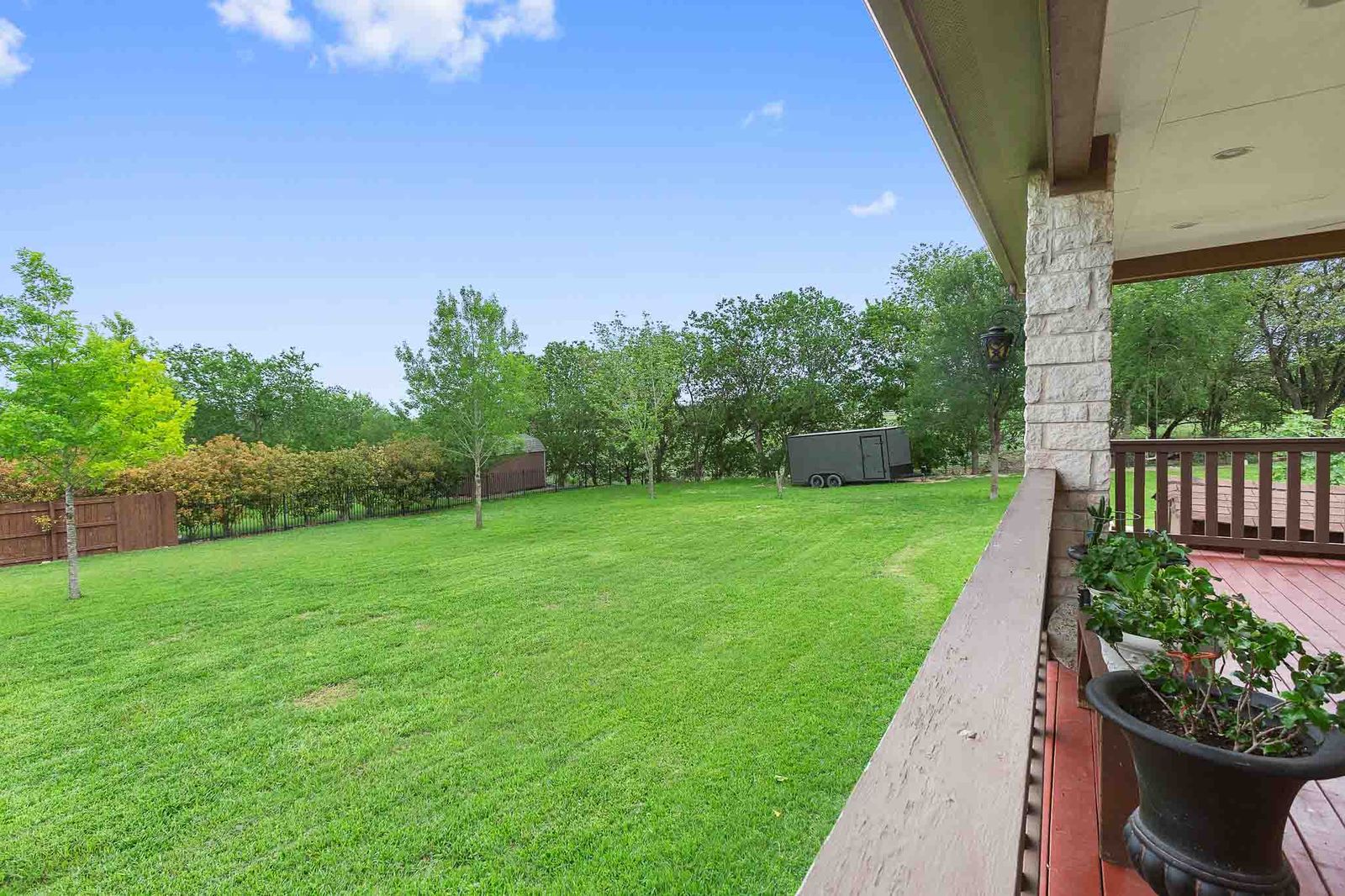 323 Woodbrook Trail Buda, TX 78610 - Photo 11 of 40 Expansive green lawn framed by a wood fence and mature trees