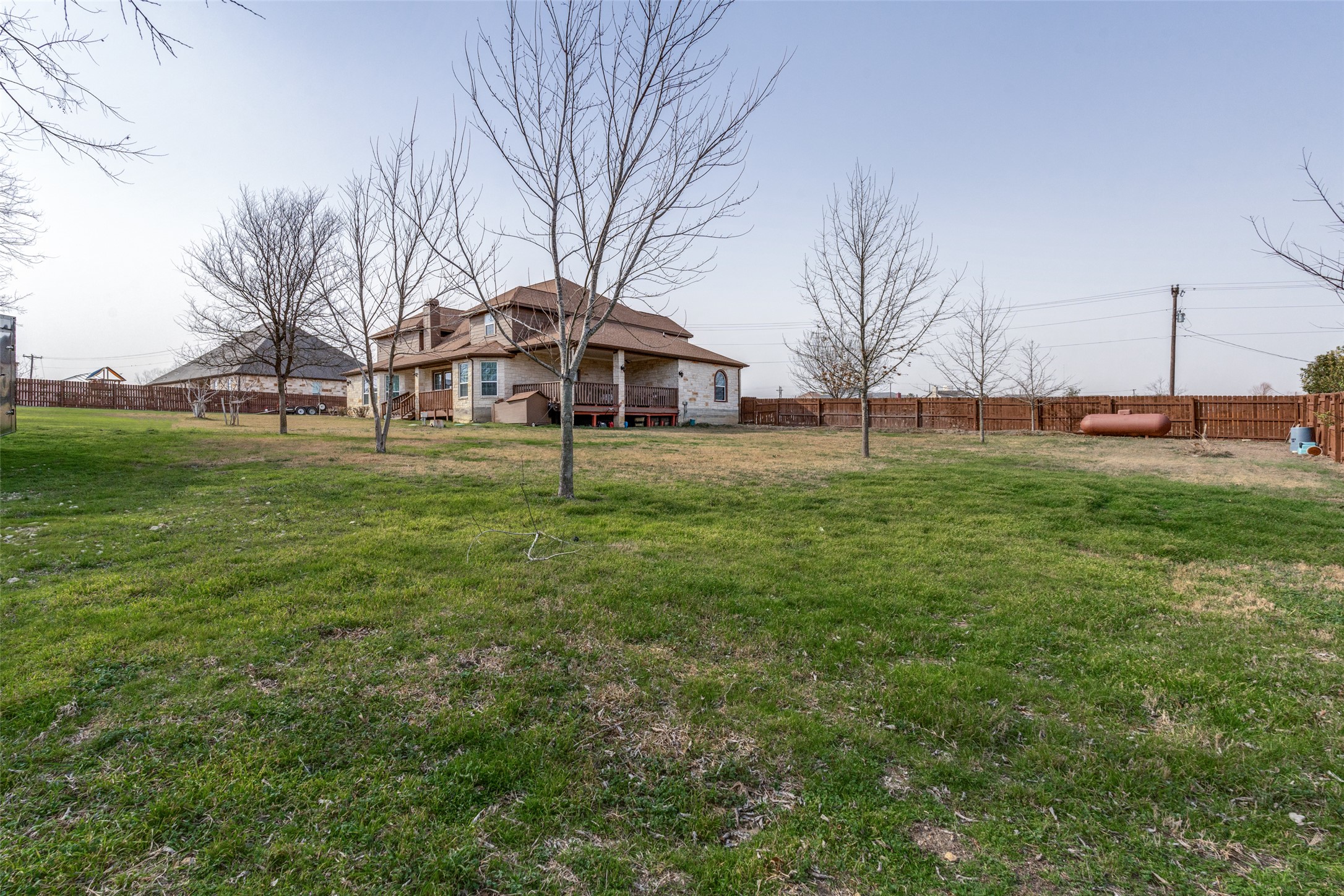 323 Woodbrook Trail Buda, TX 78610 - Photo 12 of 40 Expansive grassy backyard featuring a multi-level wood deck, a covered patio, and a wood privacy fence