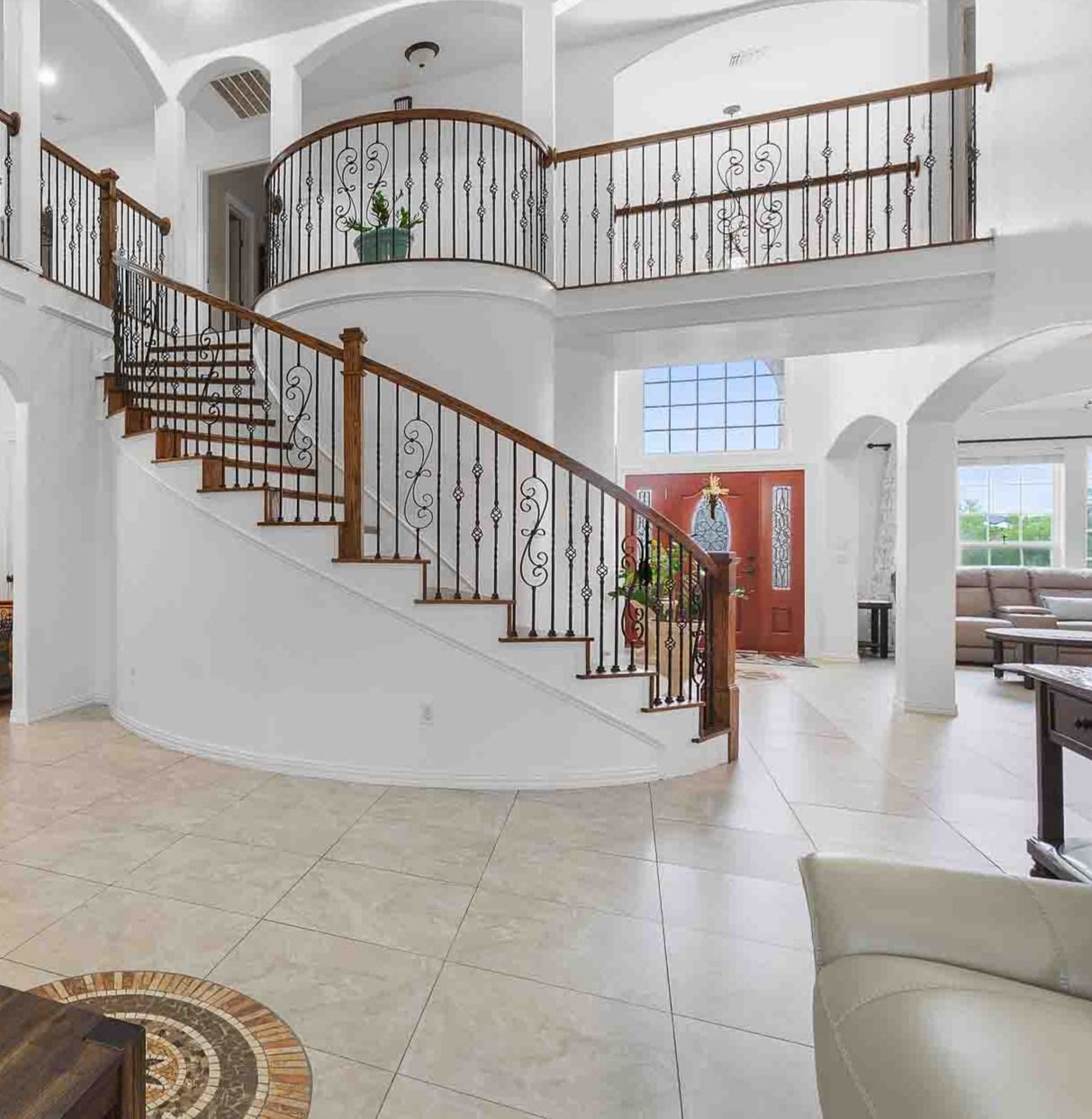 323 Woodbrook Trail Buda, TX 78610 - Photo 14 of 40 Grand foyer featuring a curved staircase with wood handrails and wrought iron balusters