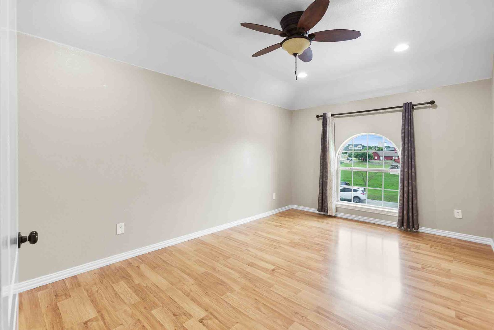 323 Woodbrook Trail Buda, TX 78610 - Photo 17 of 40 Bedroom featuring wood-finish flooring, a vaulted ceiling, and an arched window
