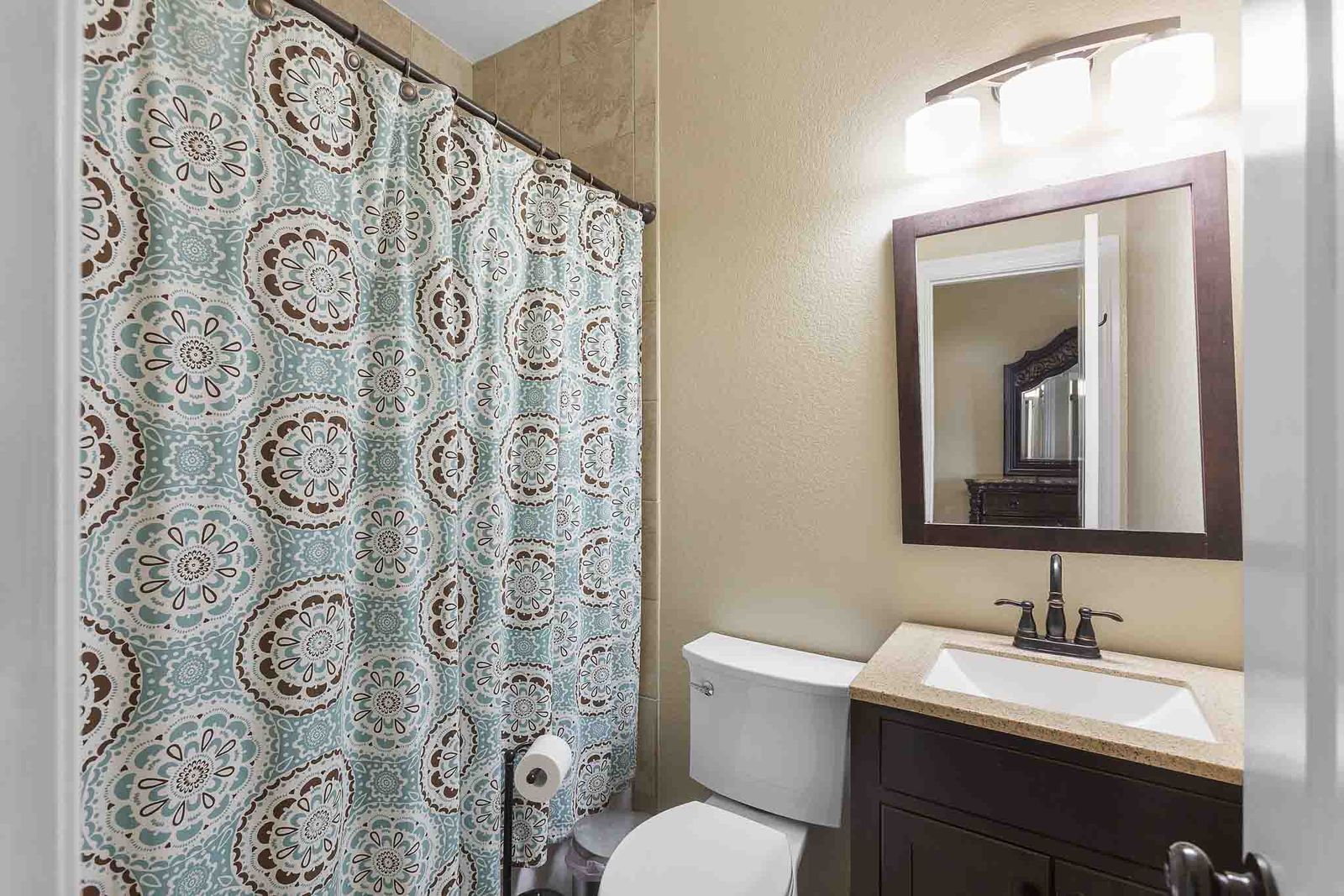 323 Woodbrook Trail Buda, TX 78610 - Photo 30 of 40 Bathroom featuring a dark wood vanity with a light-toned countertop, an integrated sink, and an oil-rubbed bronze faucet