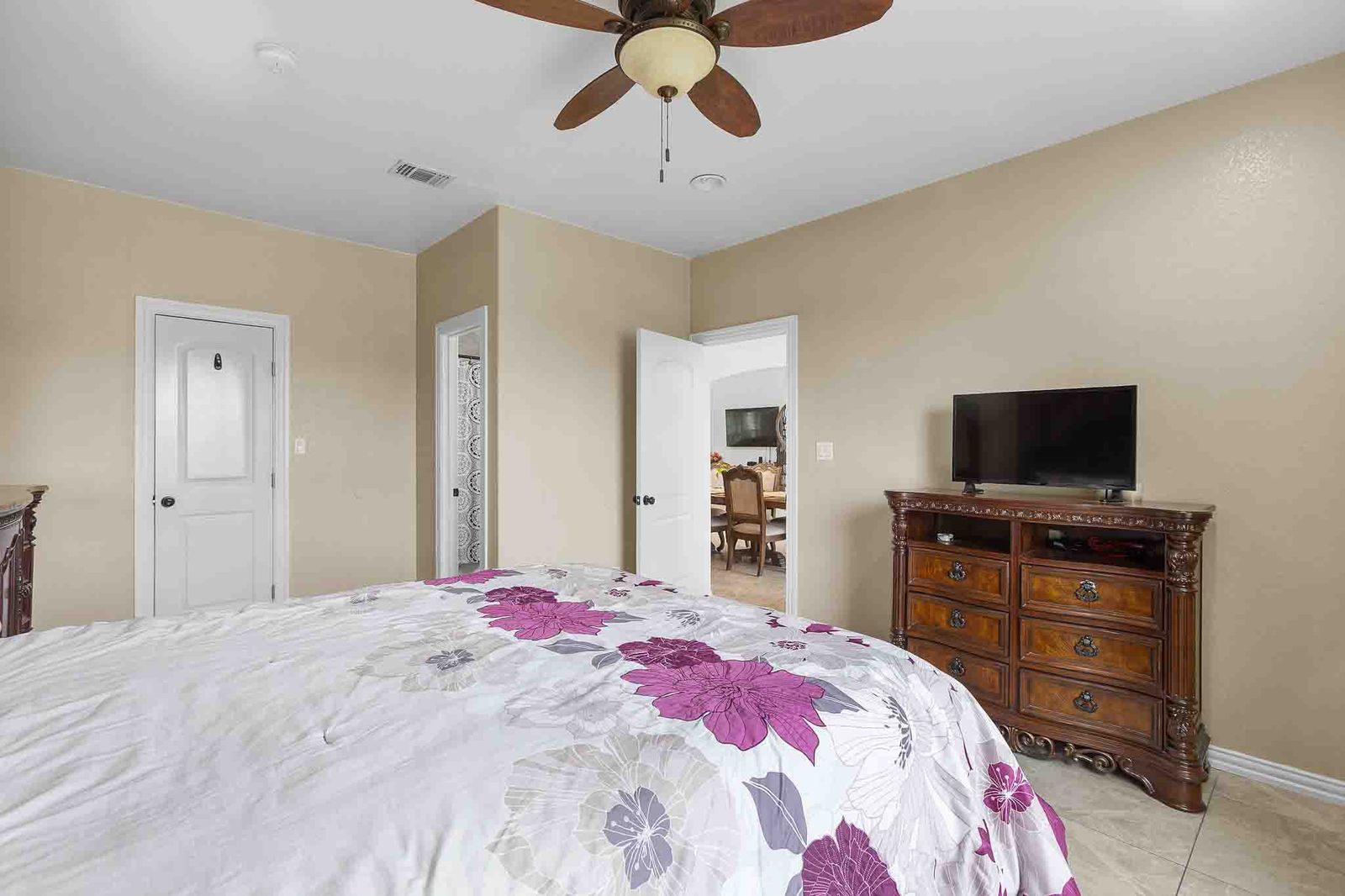 323 Woodbrook Trail Buda, TX 78610 - Photo 32 of 40 Spacious second primary bedroom featuring neutral tone walls, tile flooring, a ceiling fan with light fixture, and white interior doors