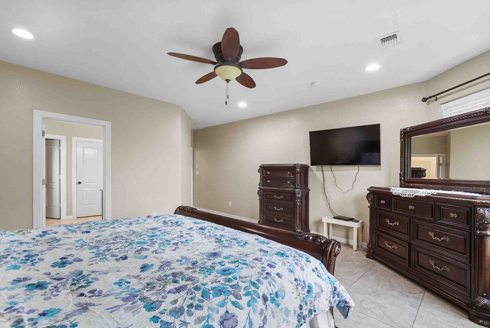 323 Woodbrook Trail Buda, TX 78610 - Photo 34 of 40 Spacious primary bedroom featuring neutral tone walls, recessed lighting, and a ceiling fan with integrated light fixture