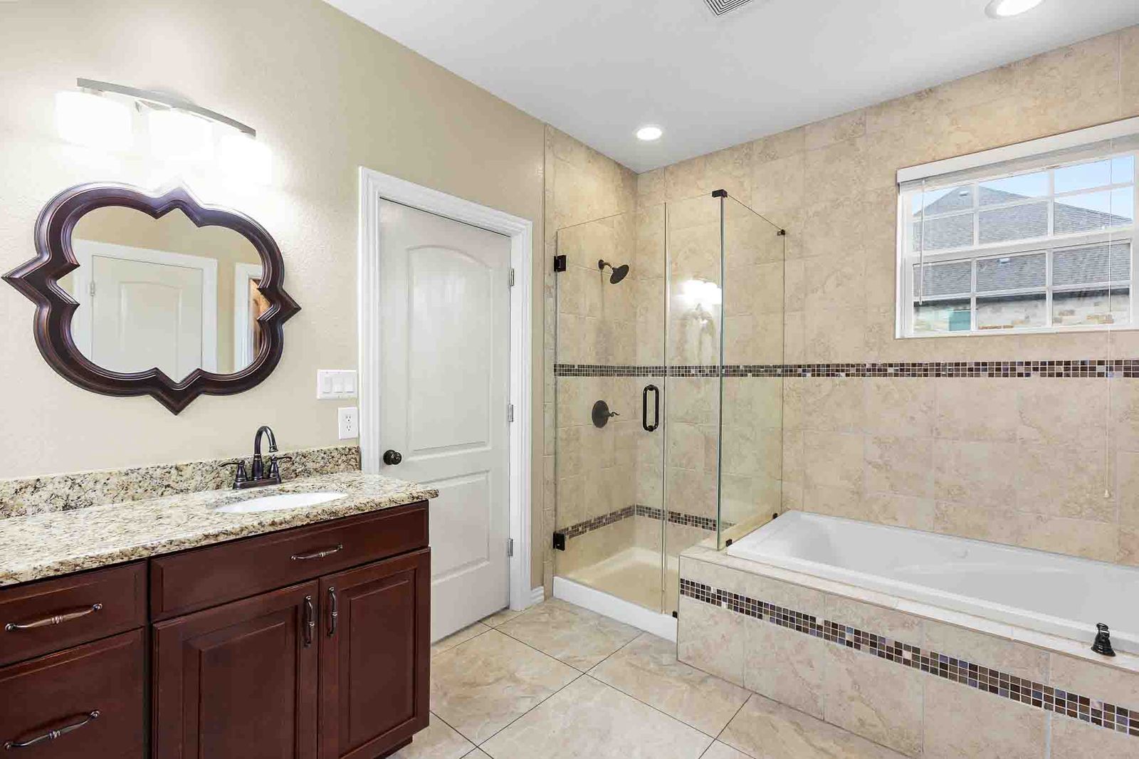 323 Woodbrook Trail Buda, TX 78610 - Photo 36 of 40 Primary bathroom featuring a walk-in glass shower, jacuzzi, a double vanity with granite countertop, and tile flooring