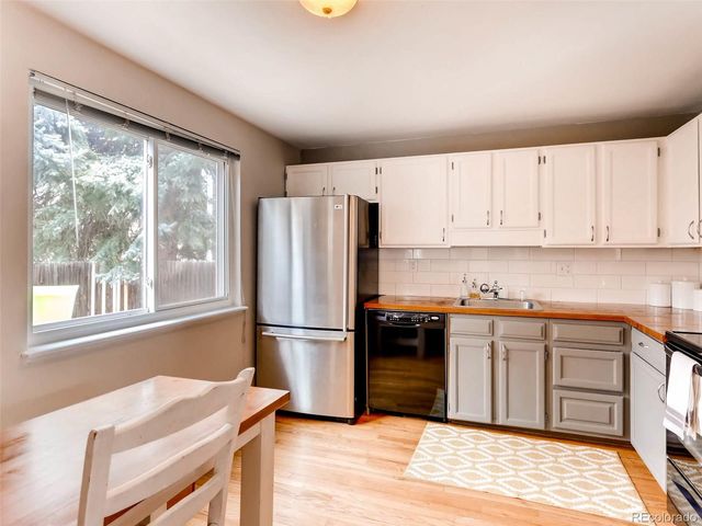 a kitchen with granite countertop a refrigerator and a stove top oven