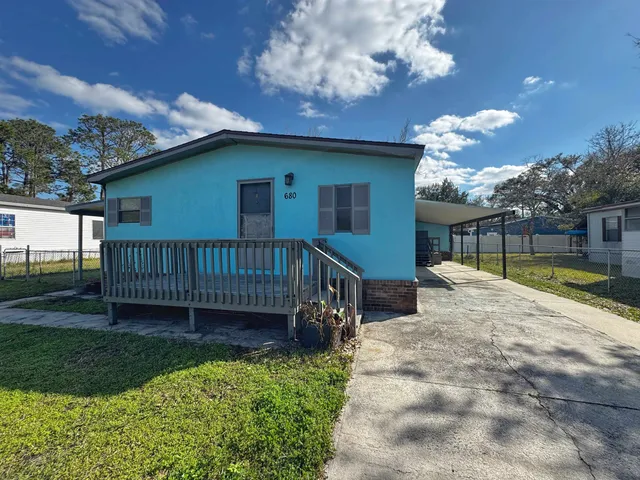 a view of a house with a yard and a wooden deck