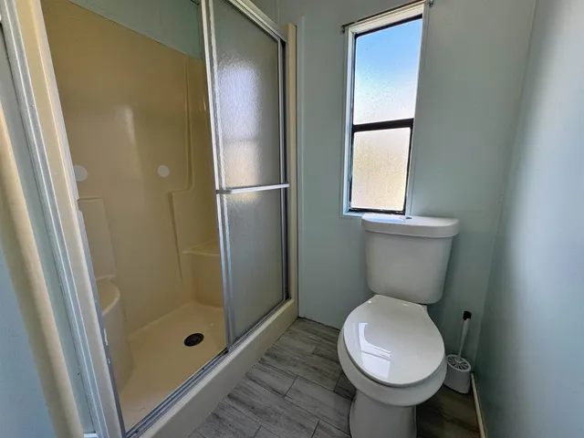 a bathroom with a toilet and a shower