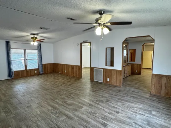 a view of a living room with wooden floor and chandelier