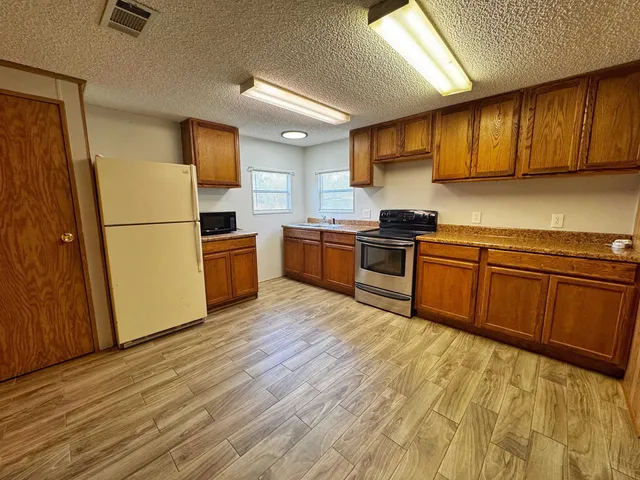 a kitchen with a sink wooden cabinets and stainless steel appliances