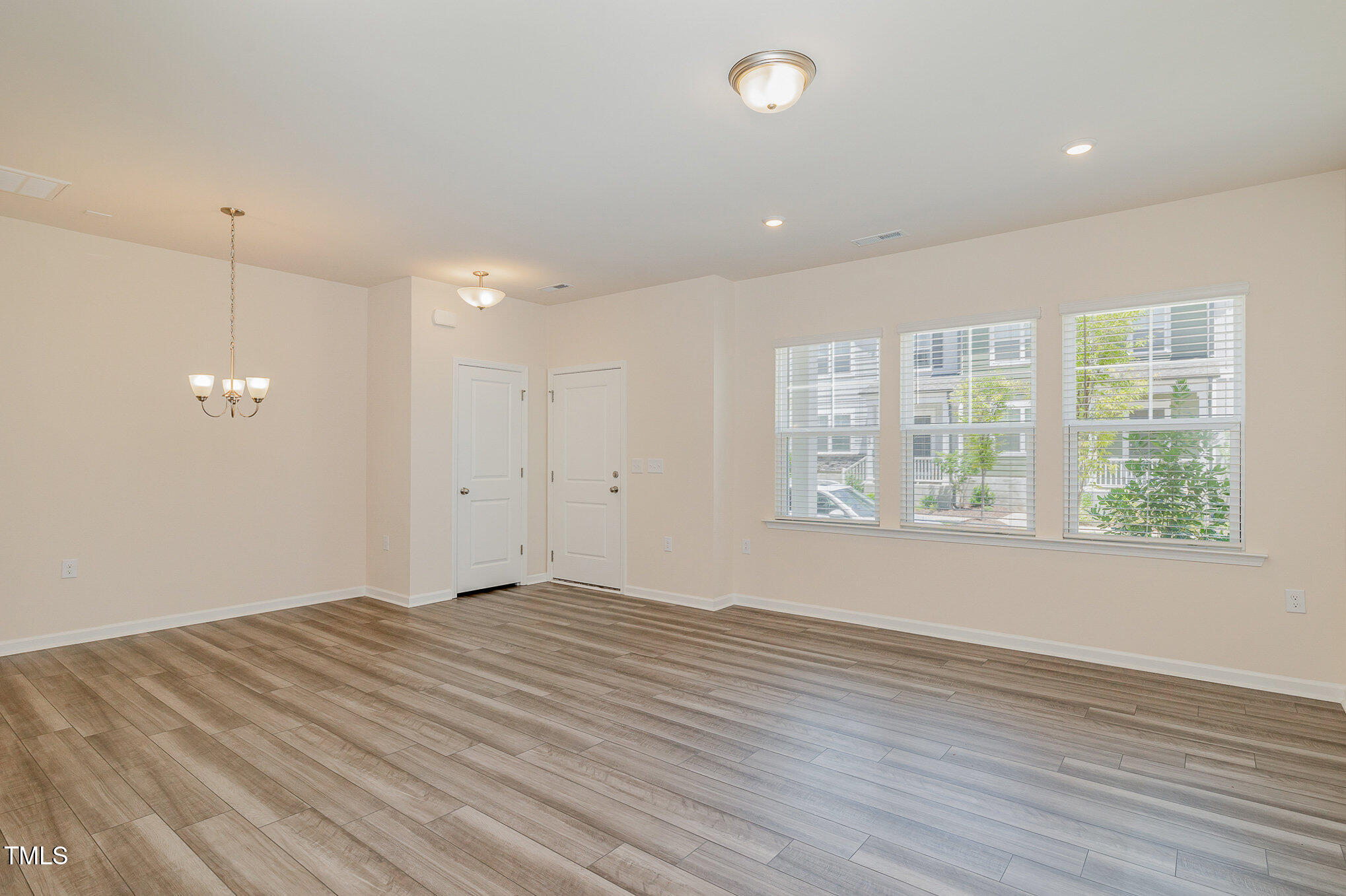 5706 Kalamata Drive Raleigh, NC 27603 - Photo 11 of 25 an empty room with wooden floor and windows