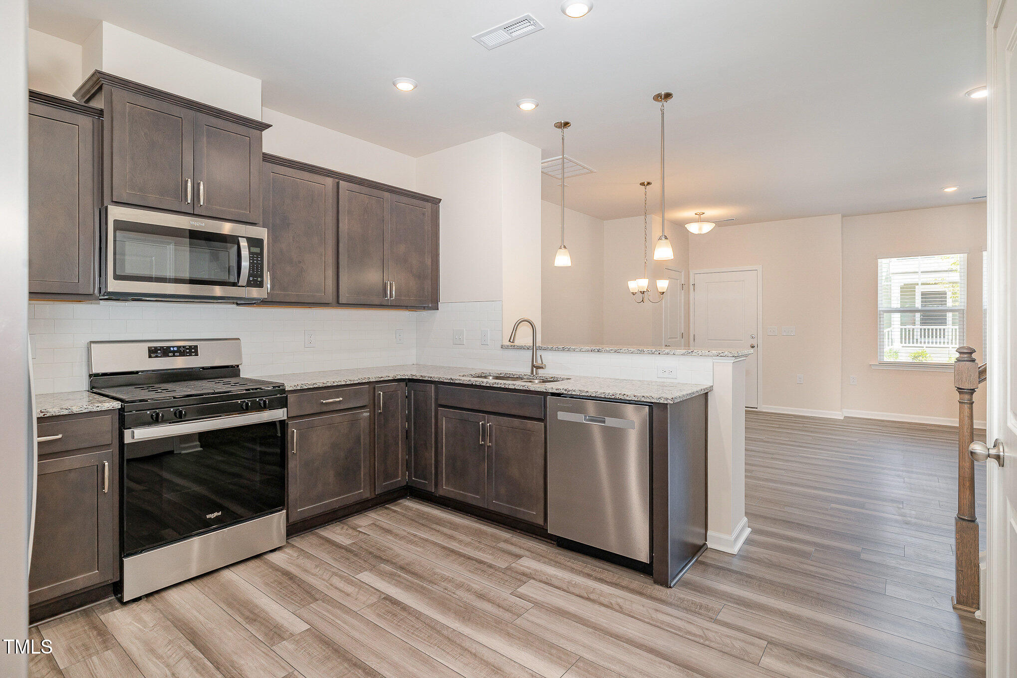 5706 Kalamata Drive Raleigh, NC 27603 - Photo 7 of 25 a kitchen with stainless steel appliances granite countertop a stove a sink and a microwave
