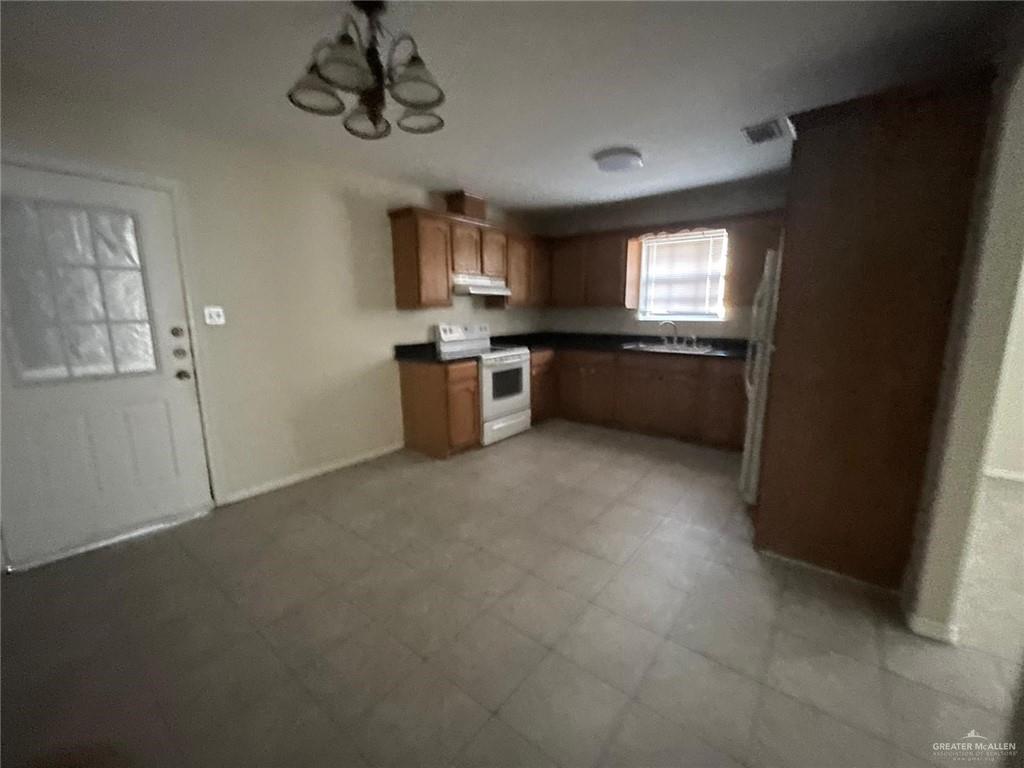 1413 Nassau Street, Unit A Edinburg, TX 78541 - Photo 2 of 9 a kitchen with stainless steel appliances granite countertop a refrigerator a sink dishwasher a stove and a refrigerator with wooden floor