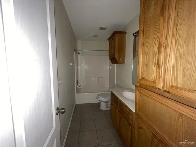 a bathroom with a granite countertop sink a toilet and shower