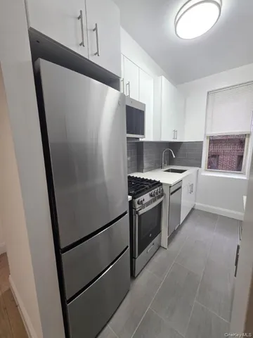 a kitchen with stainless steel appliances a refrigerator sink and stove