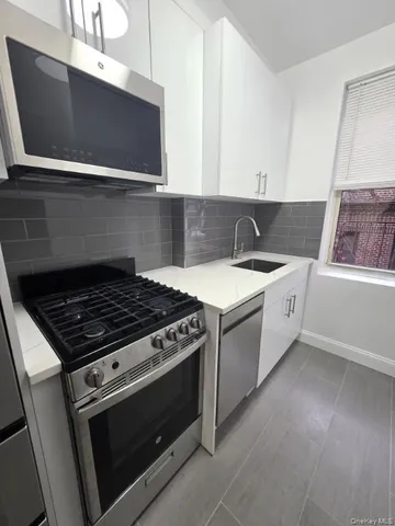 a white stove top oven sitting inside of a kitchen