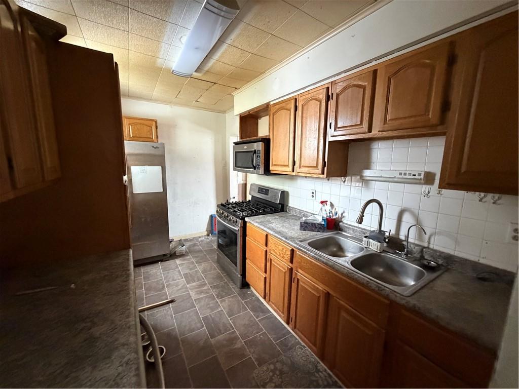 467 Reno Street Rochester, PA 15074 - Photo 6 of 11 a kitchen with stainless steel appliances granite countertop a sink stove refrigerator and cabinets
