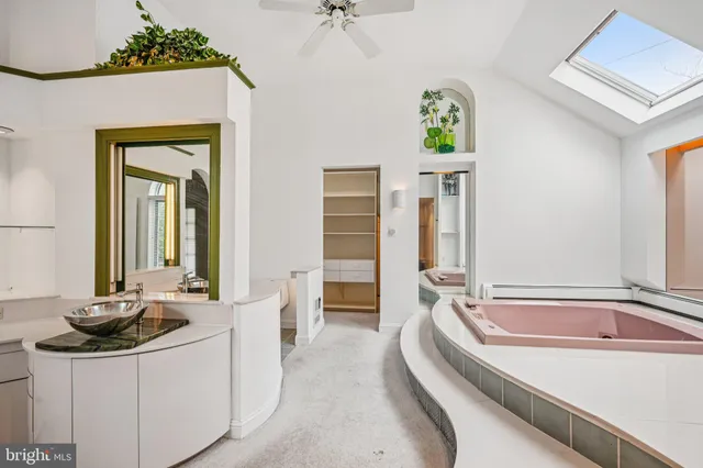 a bathroom with a tub a sink and a mirror