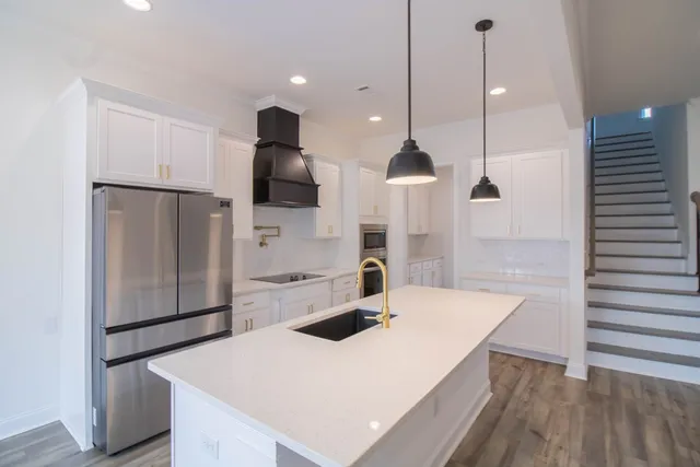 a kitchen with stainless steel appliances a refrigerator a sink a stove a microwave and island