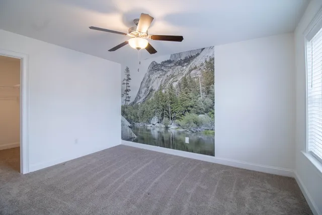 a view of a livingroom with a ceiling fan and window
