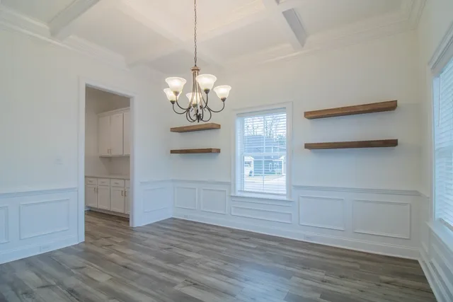 a view of a room with wooden floors and chandelier