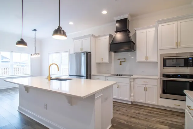 a kitchen with stainless steel appliances granite countertop a sink a stove and a refrigerator