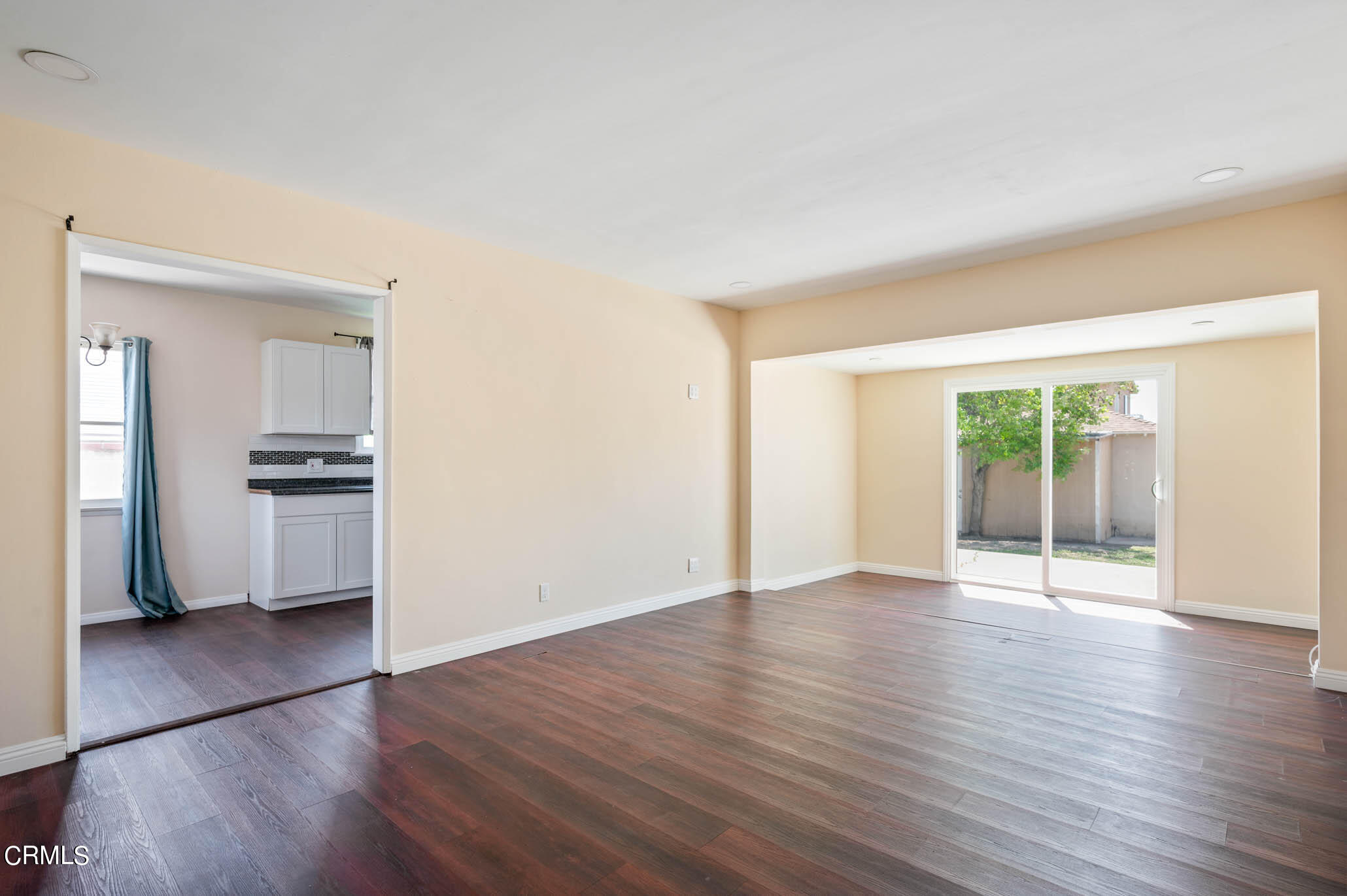 19406 Sherman Way Reseda, CA 91335 - Photo 11 of 36 an empty room with wooden floor and a kitchen