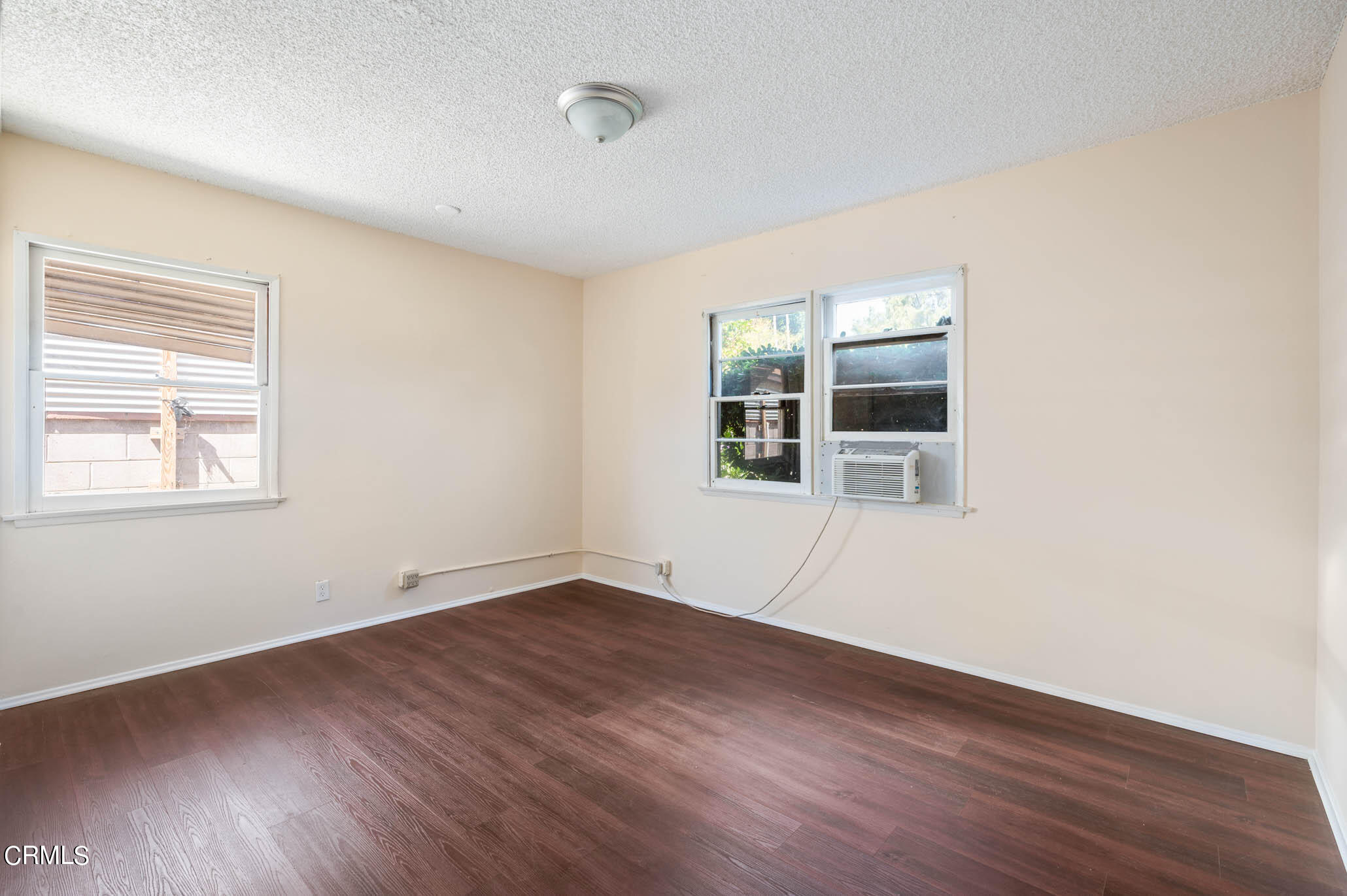 19406 Sherman Way Reseda, CA 91335 - Photo 15 of 36 an empty room with wooden floor and windows