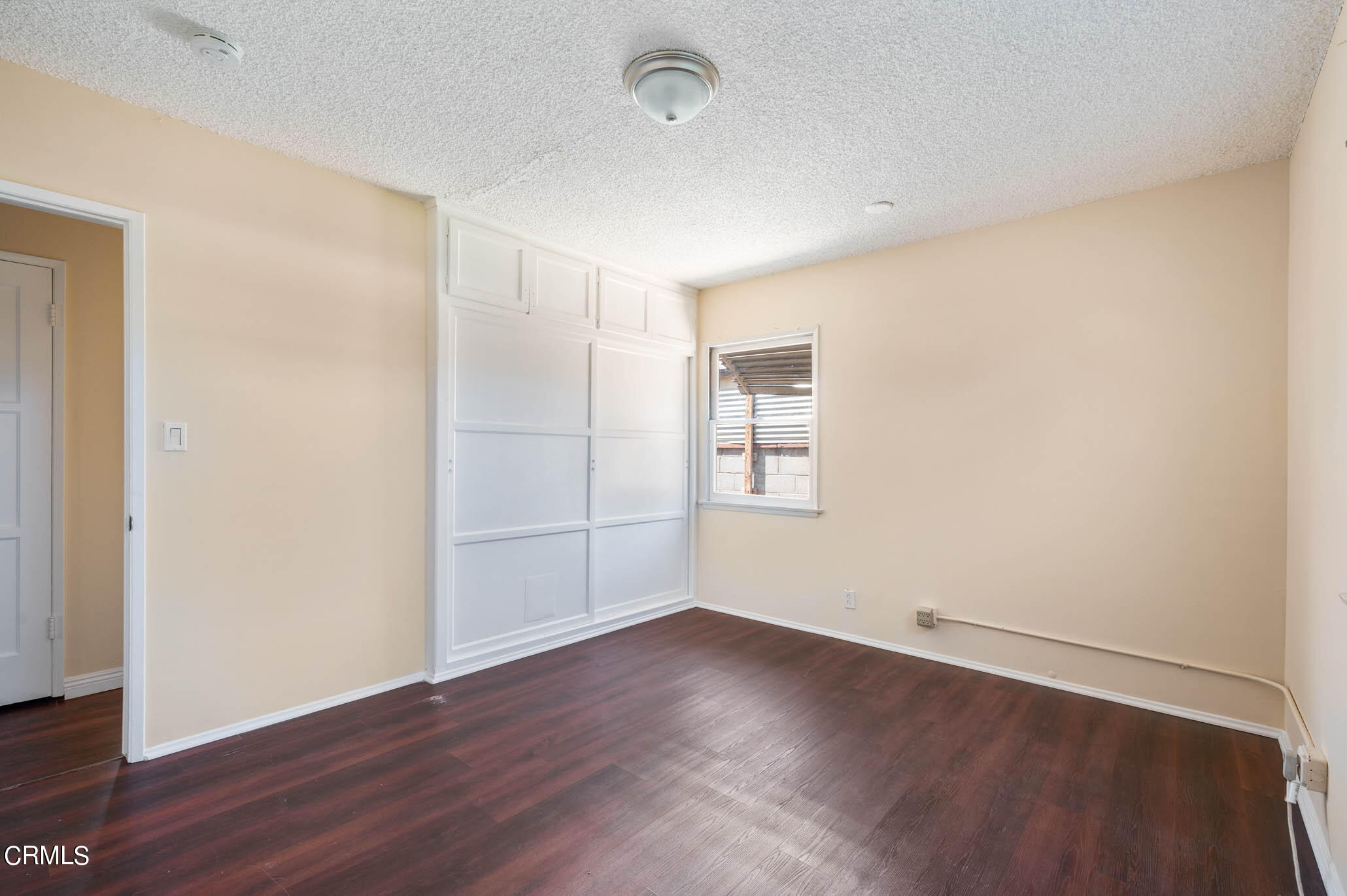 19406 Sherman Way Reseda, CA 91335 - Photo 16 of 36 an empty room with wooden floor and windows