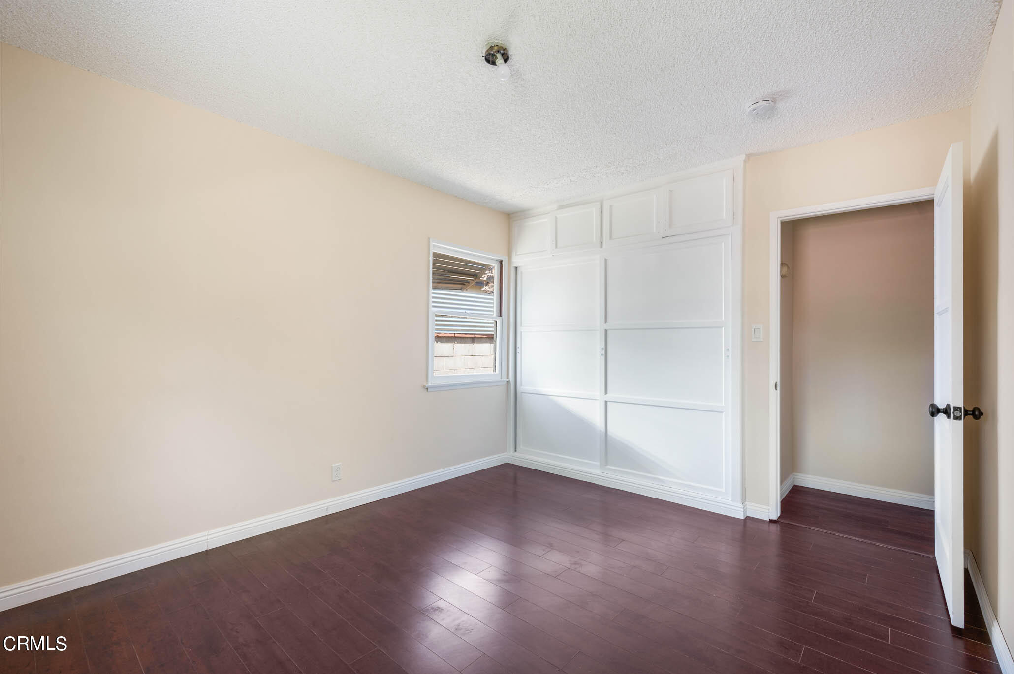 19406 Sherman Way Reseda, CA 91335 - Photo 18 of 36 a view of an empty room with wooden floor and a window