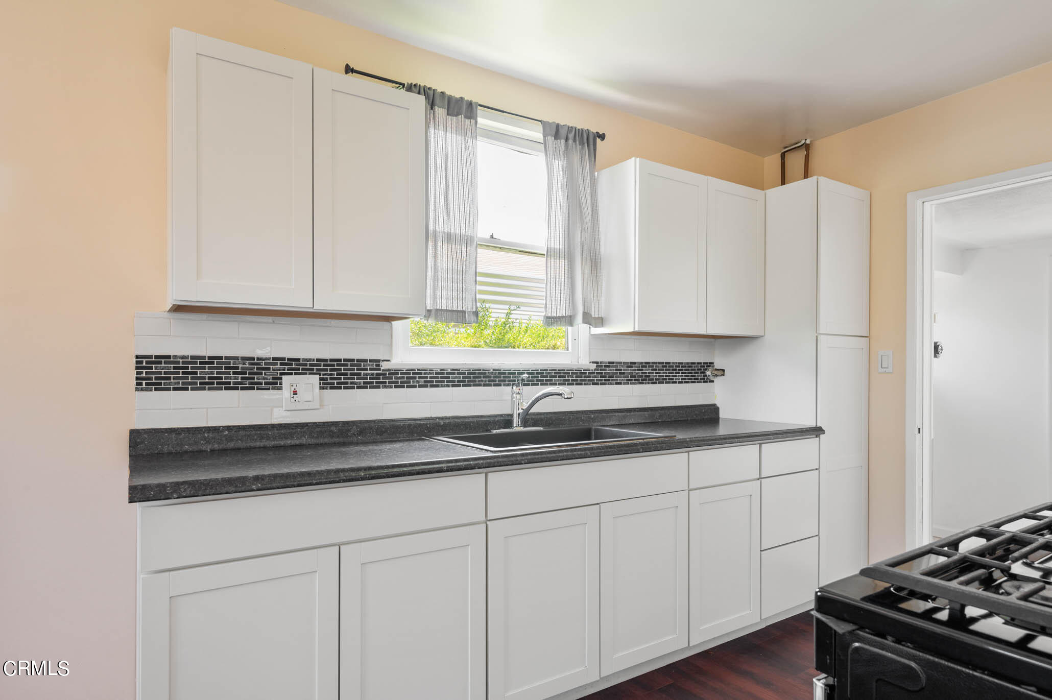 19406 Sherman Way Reseda, CA 91335 - Photo 24 of 36 a kitchen with granite countertop white cabinets and a stove