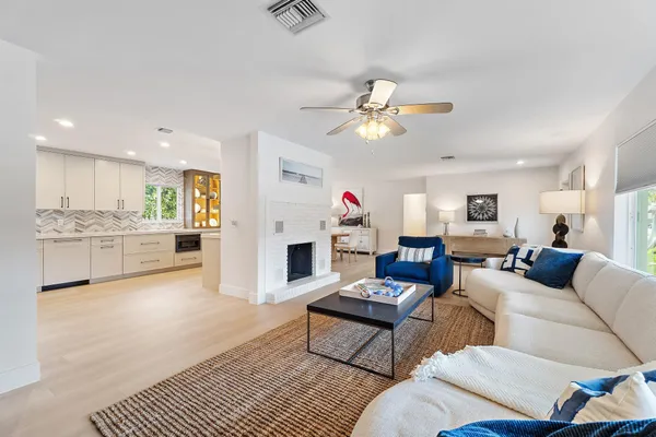 a living room with furniture a fireplace and kitchen view