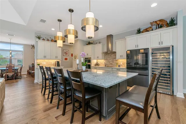a large kitchen with stainless steel appliances kitchen island granite countertop a large counter top and a stove