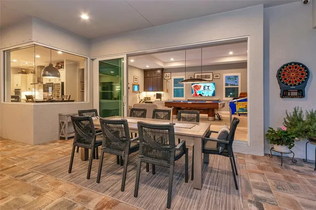 a dining room with furniture a floor to ceiling window and wooden floor