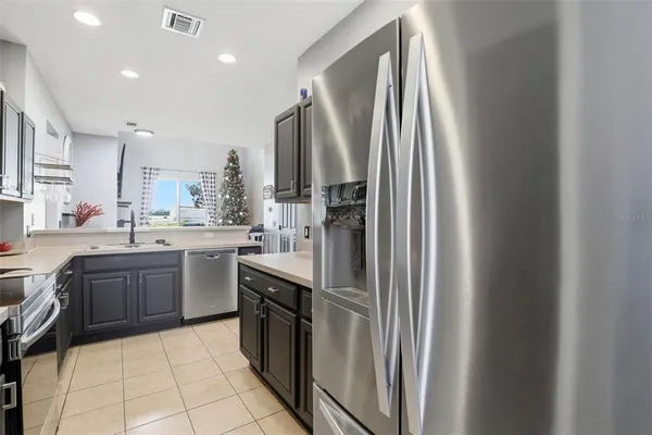 a kitchen with stainless steel appliances granite countertop a refrigerator a sink a stove and island