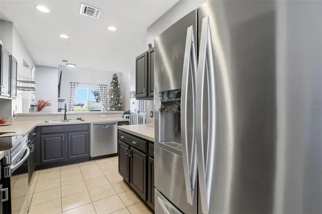 a kitchen with stainless steel appliances granite countertop a refrigerator a sink a stove and island