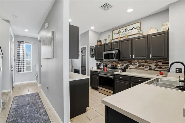 a kitchen with stainless steel appliances a sink stove refrigerator and cabinets