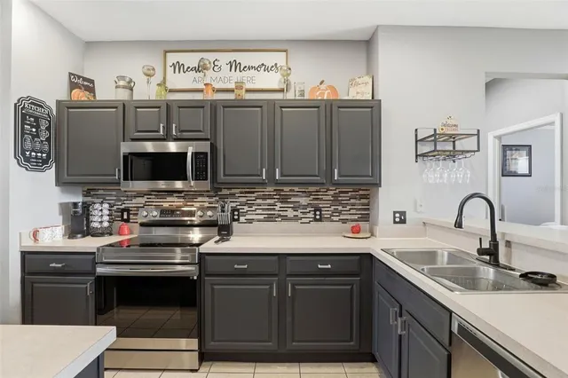 a kitchen with stainless steel appliances a stove sink and microwave